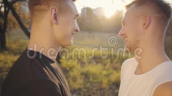 两个白人年轻人站在阳光下谈笑风生英俊强壮的运动员花时间视频的预览图