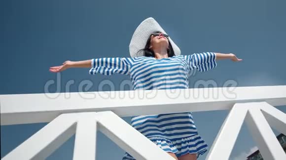 快乐的旅游妇女微笑着举起手享受蓝天背景下的暑假视频的预览图