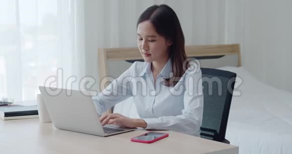 肖像年轻美女使用笔记本电脑和智能手机视频的预览图