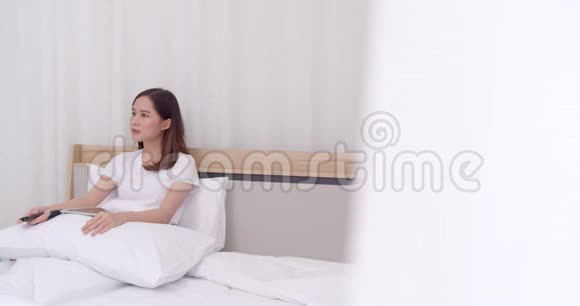 年轻女子在床上用远程闭路电视视频的预览图