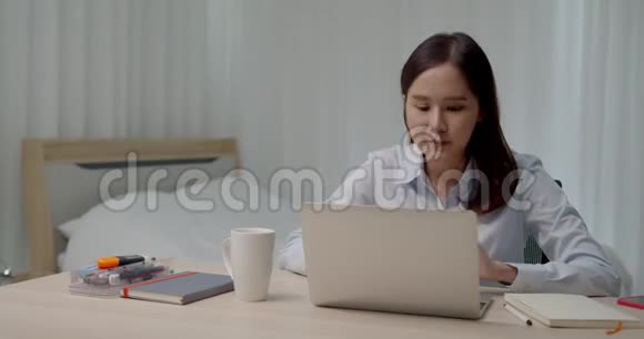 带手提电脑和智能手机在家工作的亚洲年轻女性视频的预览图