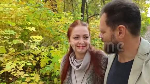 相爱的一对走在秋天公园里在电话里拍摄视频的预览图