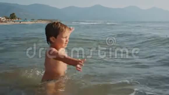 快乐的男孩在玩海浪视频的预览图
