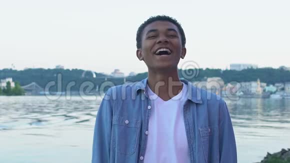黑人少年笑着真诚地站在城市的对立面享受生活视频的预览图