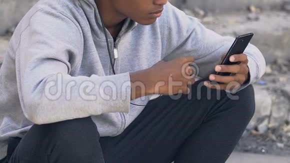 孤独沮丧的黑人青少年在耳机听智能手机音乐抑郁视频的预览图