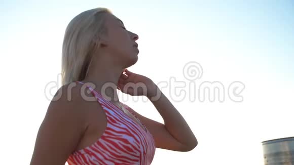 漂亮的女运动员在锻炼后休息漂亮的女运动员摇摇头用h触摸并抚平头发视频的预览图