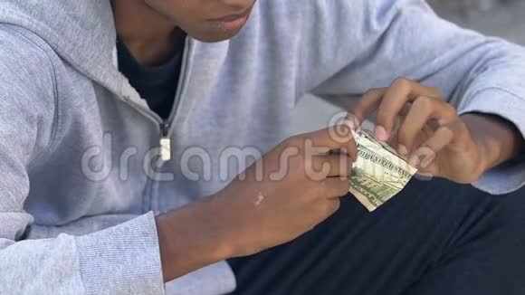 无家可归悲伤的美国黑人手里拿着最后一美元钞票贫穷视频的预览图