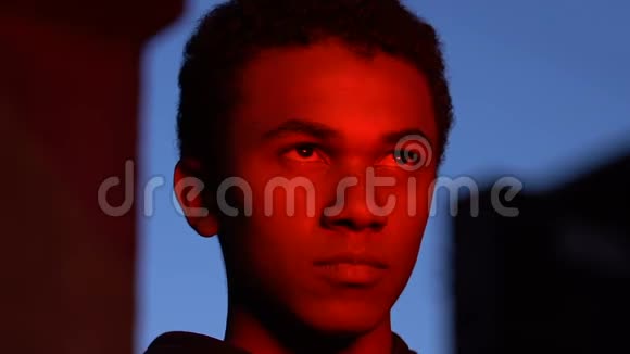 穿红灯的男青少年晚上看着火犯罪的生活方式视频的预览图