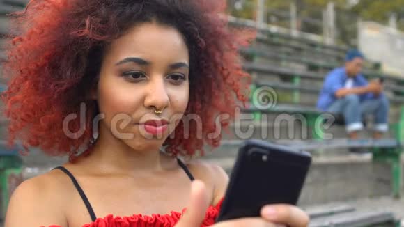 满脸通红鼻青脸肿的少女在电话里观看可怕的视频视频的预览图