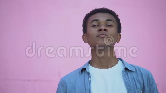 自信的非裔美国青少年微笑着相机调整头发青春期视频的预览图