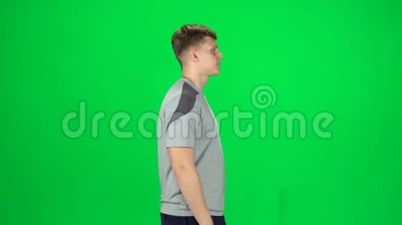 男人在绿色的屏幕上跳舞微笑和快乐ChromaKey侧视图视频的预览图