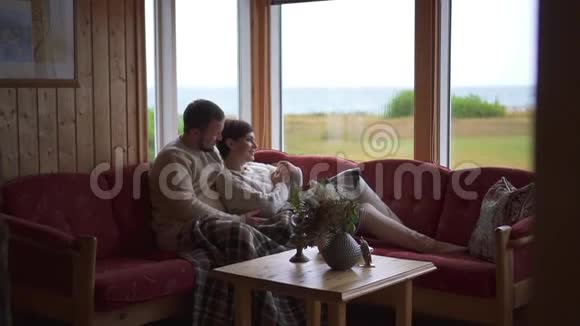 一对夫妇坐在家里的沙发上拥抱整体计划视频的预览图