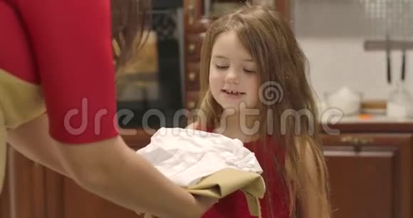 成年女性白种人给小女孩围裙和厨师帽快乐的孩子跳跃和微笑快乐的孩子视频的预览图