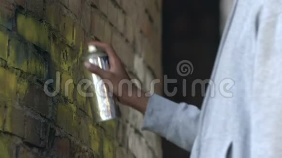 美国黑人男子在被毁的建筑墙上涂鸦彩色颜料视频的预览图