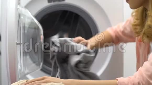 精疲力竭的年轻家庭主妇装洗衣机厌倦了日常生活视频的预览图