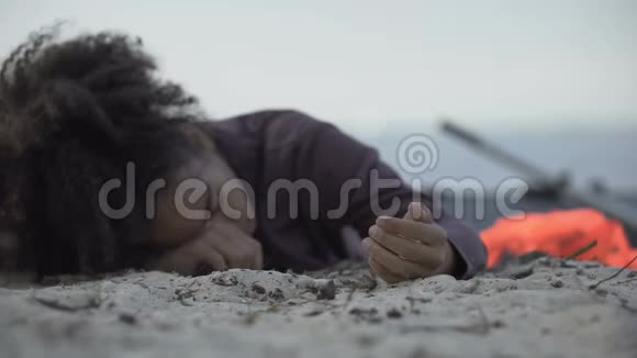 双种族女孩躺在沙滩上咳嗽难民在海难中幸存灾难视频的预览图