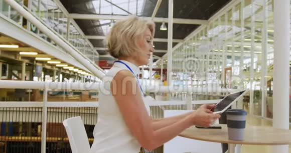女商人用平板电脑在会议大厅喝咖啡视频的预览图