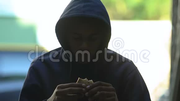 无家可归的非洲裔美国男性青少年吃最后一块面包贫穷视频的预览图