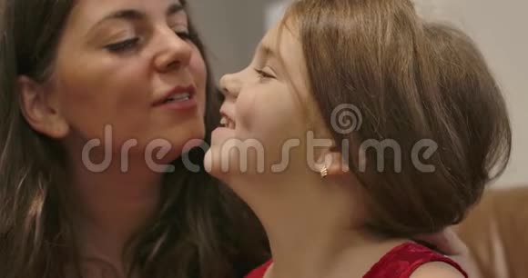 小白种人黑发女孩的特写亲吻她可爱的母亲微笑妈妈把她可爱的女儿视频的预览图