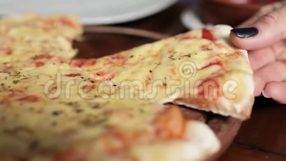 一个女人她的手拿着一片披萨上面有融化的奶酪视频的预览图