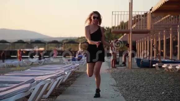 一个穿着黑色短裙的年轻女子在河堤上漫不经心地跳舞晚上视频的预览图
