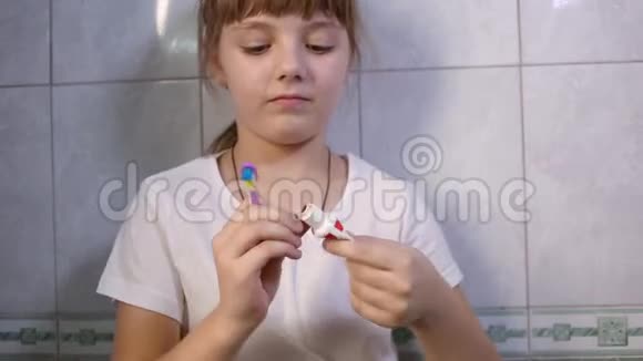女孩挤牙膏在刷子上开始刷牙防龋预防视频的预览图