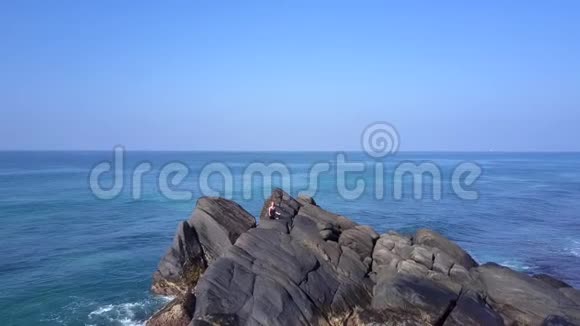 女孩剪影练习瑜伽悬崖环绕海洋视频的预览图