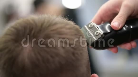 年轻人理发店理发主裁剪头发的特写视频的预览图