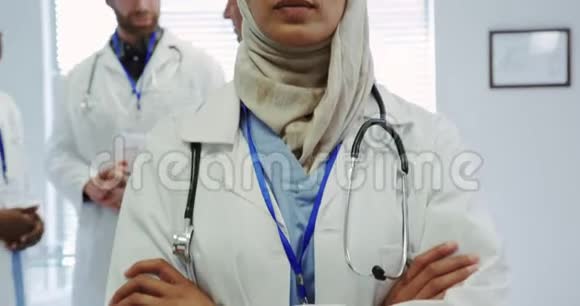 在医院交叉双臂站立的中东女医生的正面视角视频的预览图