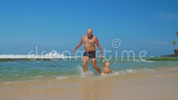 父亲在海水中玩儿子拉孩子的游戏视频的预览图