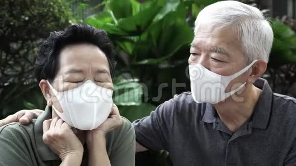戴口罩的中国老夫妇保护病毒不受爆发污染的威胁视频的预览图