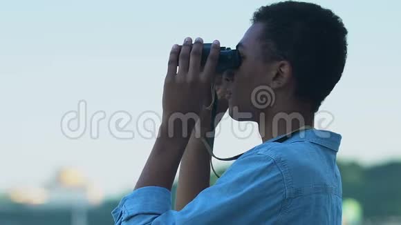 非洲裔美国男性游客用望远镜观察风景旅程视频的预览图