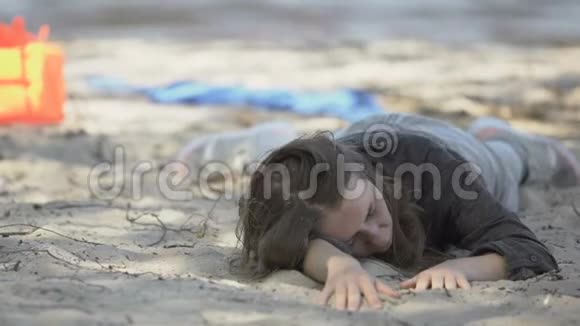 难民痛苦地躺在海滩上看着摄像机请求帮助视频的预览图