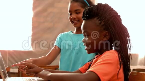 小女孩在教室里用笔记本电脑视频的预览图