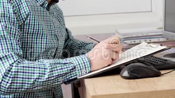 商人坐在他的办公桌前工作着台式电脑视频的预览图