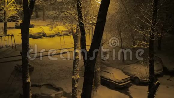 夜晚的住宅院子里覆盖着雪下雪了视频的预览图