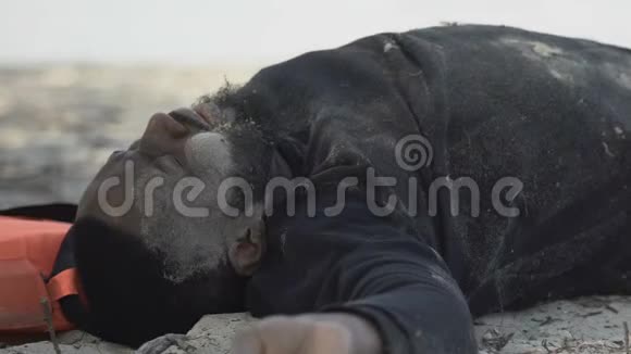 带着精神创伤的黑人躺在海滩上深呼吸自然灾害视频的预览图