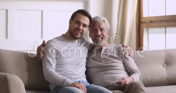 年长的父亲和成年的儿子抱着笑看着镜头视频的预览图