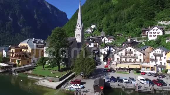 空中无人机4k全景飞越奥地利小舒适的房子村在美丽的山林景观湖滩视频的预览图