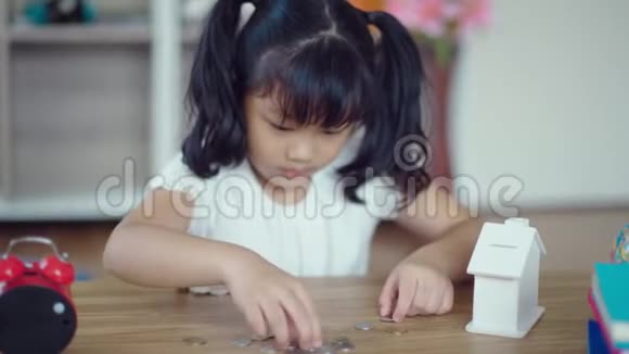 3小女孩正在收拾桌子上的硬币视频的预览图