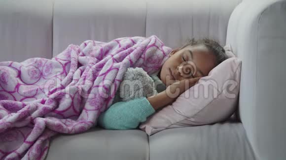 小可爱的黑人女孩睡在沙发上视频的预览图
