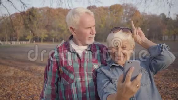 积极资深欧洲家庭在秋季公园自拍快乐的现代白种人夫妇有角和角视频的预览图