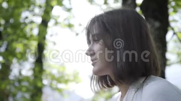 年轻的黑发女子肖像微笑在公园或森林中成功视频的预览图