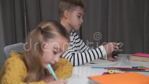 侧面看白种人男孩在智能手机上玩游戏因为他的女同学写下来不同的行为视频的预览图