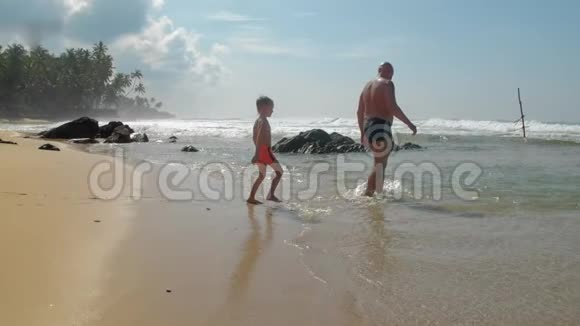 父亲和小儿子在度假村慢动作来到大海视频的预览图
