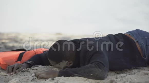 躺在海滩上的苦恼的难民带着恳求寻求帮助的目光坠机幸存者视频的预览图