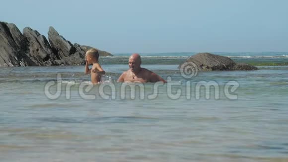 快乐的男人和小儿子一起度过蔚蓝的海湾视频的预览图