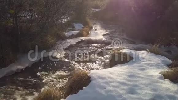 倾斜向上的太阳光束照亮了山景上的一条小溪视频的预览图