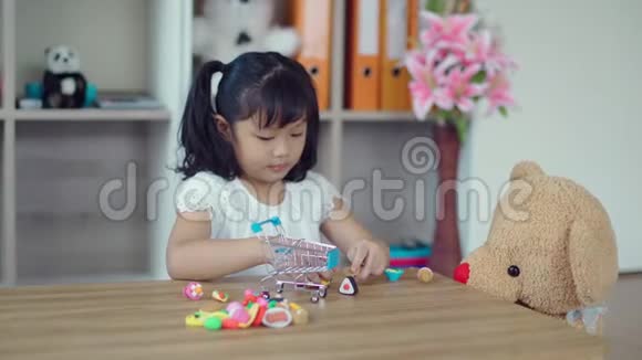 可爱的女孩在客厅玩玩具熊视频的预览图