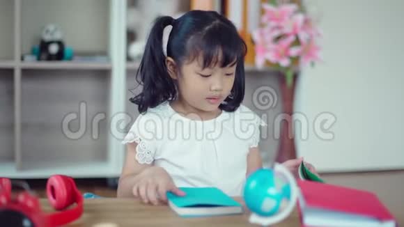 可爱的女孩在看书吃饼干视频的预览图